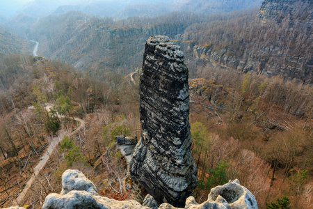 Majestic rock formation in serene mountain landscape with sparse forest.の写真素材