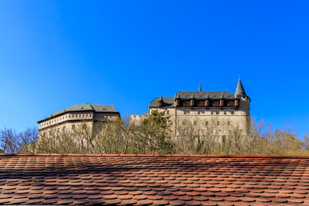 Historic medieval castle with slate roofs against clear blue sky.の写真素材