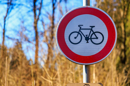 No bicycles sign in forest setting with blue sky.の写真素材