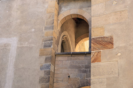 Historic stone architecture with arched windows on weathered wall.