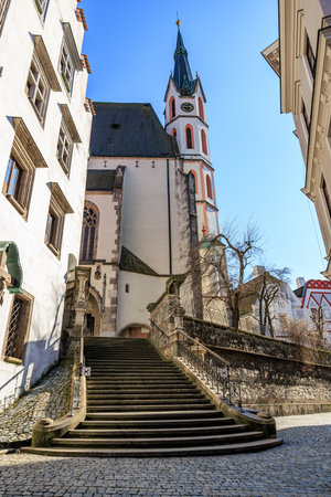 Historic church tower and stone staircase in picturesque european town.の写真素材