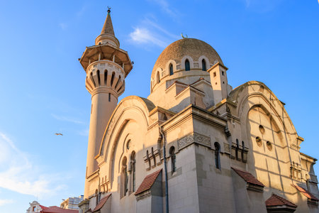 Historic constanta mosque with minaret and dome under blue sky.の写真素材