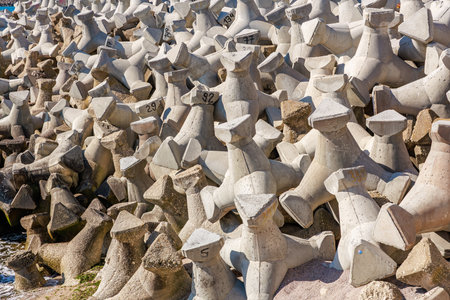 Concrete breakwaters on rocky shoreline coastal erosion prevention structures.の写真素材