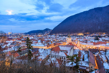 A city at night with a large building in the middle. The sky is cloudy and the city is lit upの写真素材