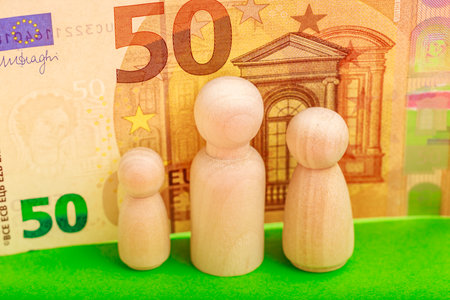 Wooden figures and euro note background highlighting economic value concept.