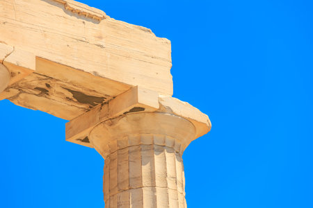 A pillar with a blue sky in the background. The pillar is made of stone and has a weathered lookの写真素材