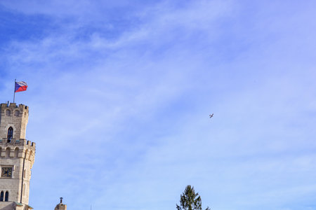 Historic castle tower with flag against blue sky.の写真素材