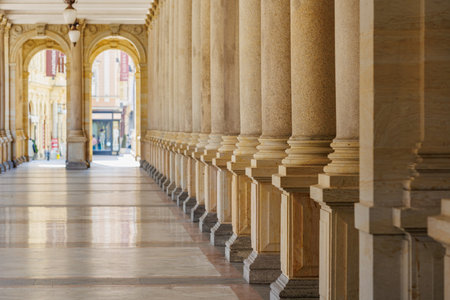 Elegant stone pillars and arches in historic arcade walkway.の写真素材