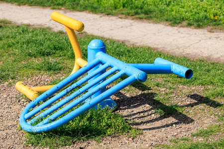 Colorful metal playground equipment fallen on grass.の写真素材