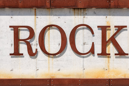 Rustic metal lettering spelling rock on weathered surface.の写真素材