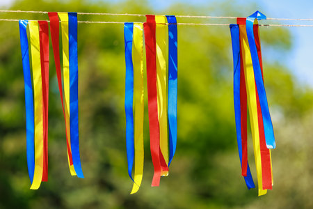Colorful ribbons hanging outdoors in bright sunlight.