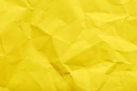 Crumpled yellow paper texture with geometric patterns.の写真素材