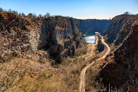 Scenic view of abandoned limestone quarry with blue lake and rocky cliffs.