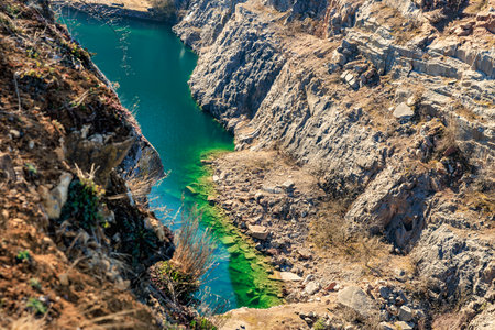 Stunning aerial view of rocky canyon with vibrant green water and rugged cliffs.の写真素材