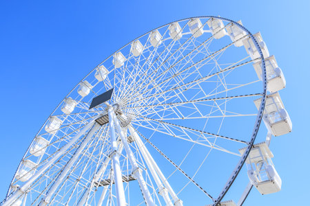 Giant white ferris wheel against clear blue sky.の写真素材