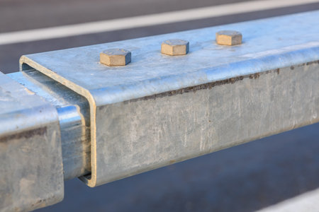 Metal guardrail close-up with nuts and bolts on highway.の写真素材