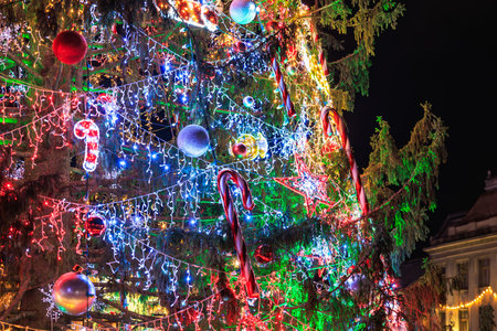 A Christmas tree with many lights and ornaments. The tree is lit up and has a festive moodの写真素材