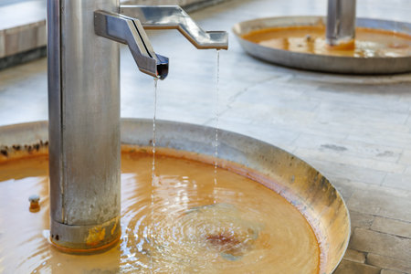 Thermal mineral water fountain in spa resort setting with flowing iron-rich water.の写真素材