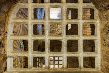Ancient brick cell interior with iron bars in historic structure.の写真素材