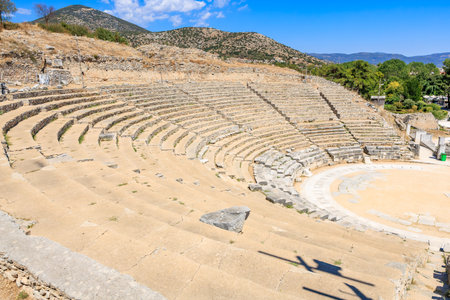 A large stone amphitheater with a stone block in the middle. The amphitheater is empty and the stone block is in the center of the stage. Ruins of the ancient city of Philippi, Greeceの写真素材