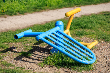 Colorful fallen childrens playground equipment on grass.