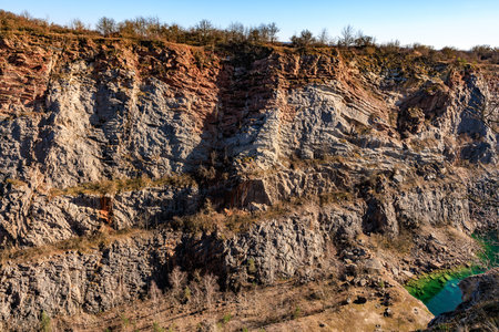 Majestic rocky canyon with vegetation and blue sky.