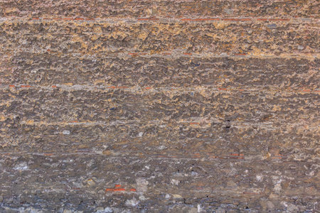 Textured stone wall with layers of rough, natural surface patterns.