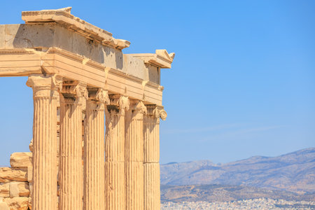 The building is a temple with columns and a blue sky in the background. The temple is located in a mountainous area, Acropolis in Athensの写真素材