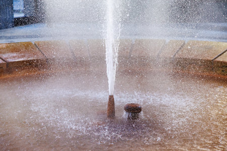 Water fountain splashing with central jet in circular basin.の写真素材