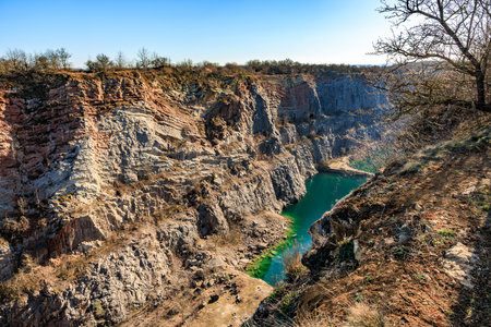 Scenic view of quarry canyon with emerald green water and rocky cliffs in nature.