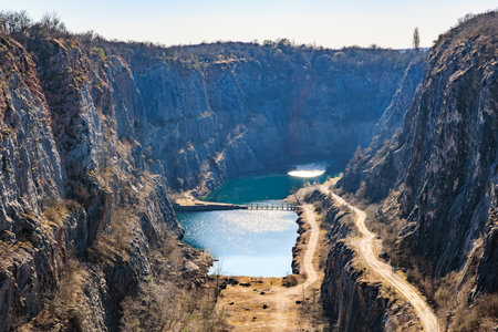 Scenic gorge with serene lake and rocky cliffs under clear sky.の写真素材