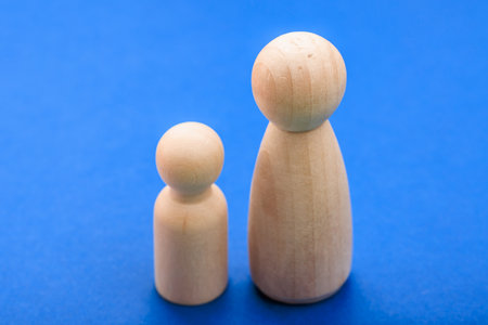 Two wooden peg figures on blue background symbolizing family and togetherness.
