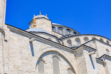 Architectural detail of historic mosque with blue sky background.の写真素材