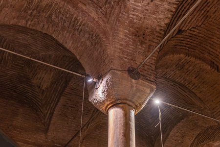 Ancient underground basilica cistern architecture with illuminated pillars and arched ceiling.
