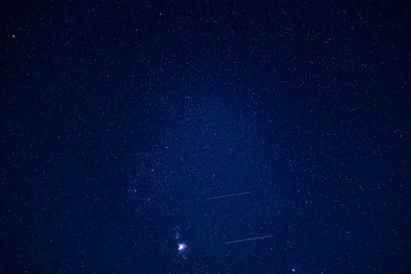 Clear night sky with orion constellation and meteor streaks.の写真素材
