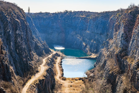 Scenic view of quarry lake and cliffs with road in natural landscape.