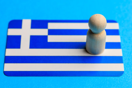 Wooden figure on greek flag background: minimalist representation of greece.の写真素材