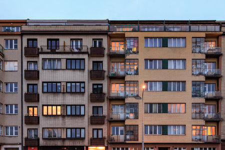 Evening view of urban apartment buildings with illuminated windows.の写真素材