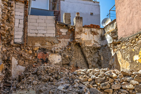 Urban decay crumbling building ruins with exposed brick and stone debris.の写真素材