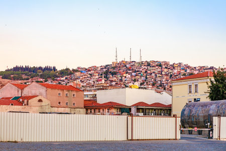 Colorful urban hillside with residential buildings and rooftops at sunset. August 4, 2025, Izmir Turkey.のeditorial素材