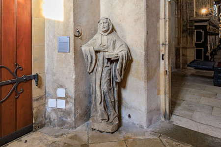 Stone monk statue holding book in historic cathedral corner.. March 22, 2025, Kutna Hora, Czech Republic.のeditorial素材
