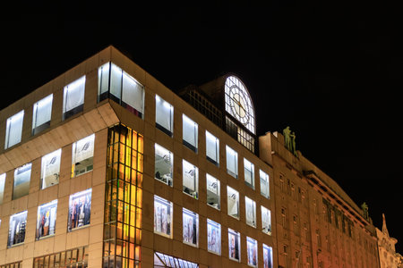 Colorful night view of illuminated modern building with clock in urban setting. March 22, 2025 Prague Czechia.のeditorial素材