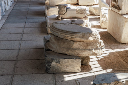 Ancient greek ruins with sunlit stone column fragment in historical site.