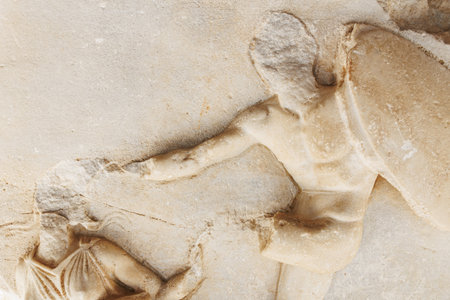 Ancient stone relief sculpture depicting battle scene with warriors.の写真素材