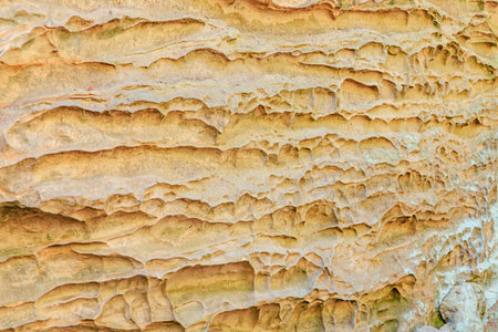 Eroded sandstone rock formation with textured layers in natural setting.の写真素材