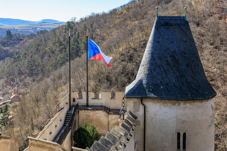 Czech castle view with tower, czech flag, and autumn landscape.の写真素材