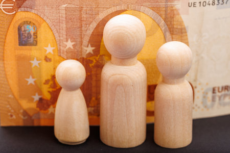 Wooden figures on euro banknote representing diverse financial concepts.