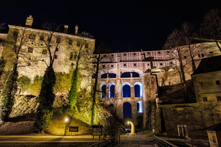 Majestic night view of lit bridge architecture at historic european castle. March 20, 2025, Cesky Krumlov, Czechia.のeditorial素材