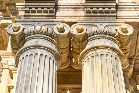 Ancient roman columns with corinthian capitals in sunlight.