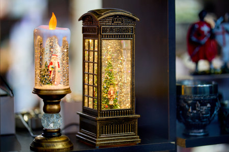 Festive lantern and candle decoration with vintage telephone booth design. December 13, 2025 Sinaia Romania.のeditorial素材